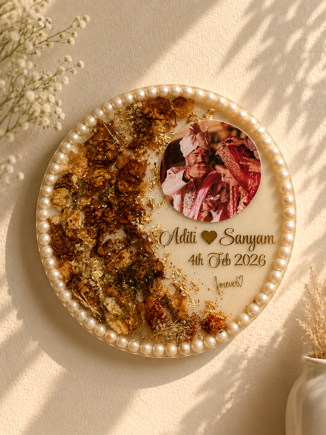 Round resin frame with pearl border, dried flowers, gold foil, and couple photo